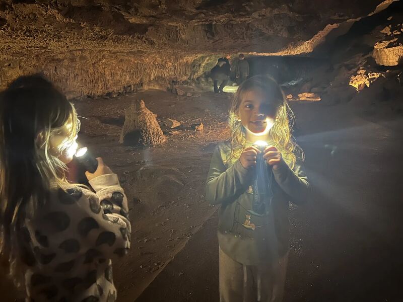 Children smiling by a campfire at night