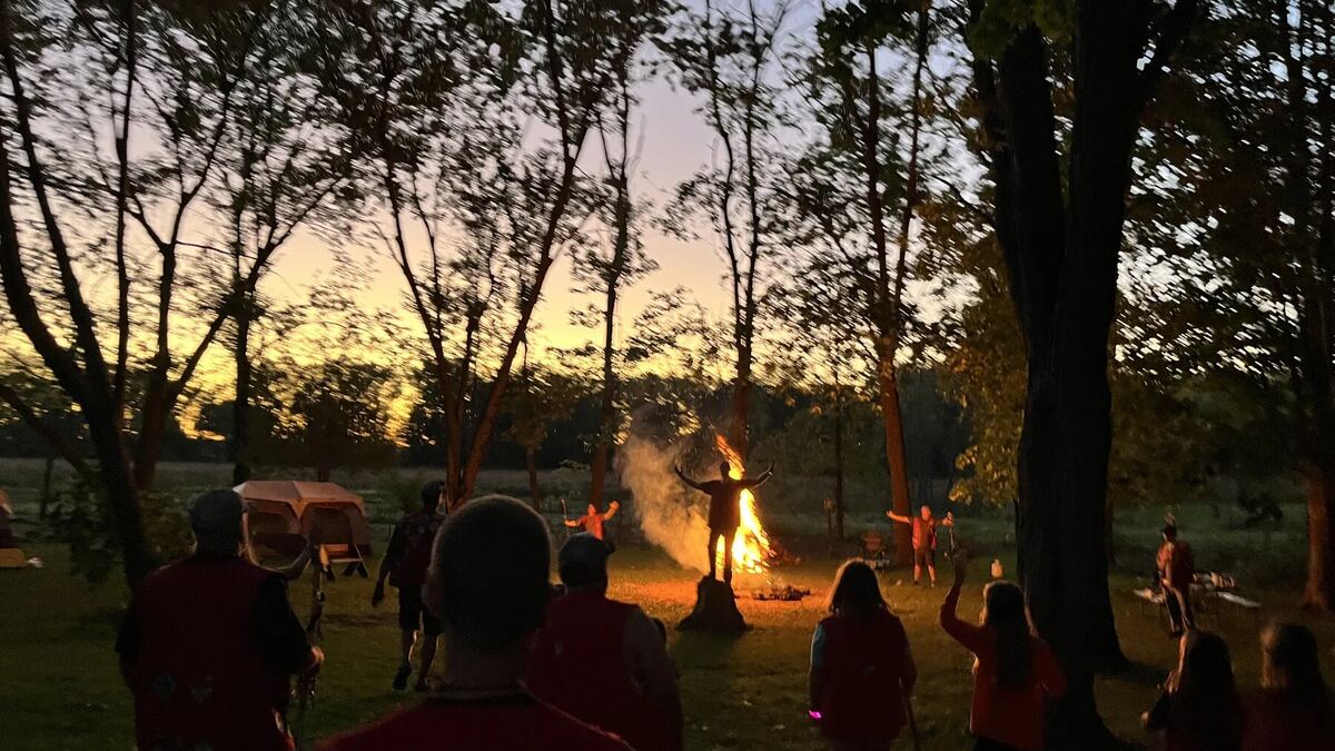 Families gathered around an evening campfire
